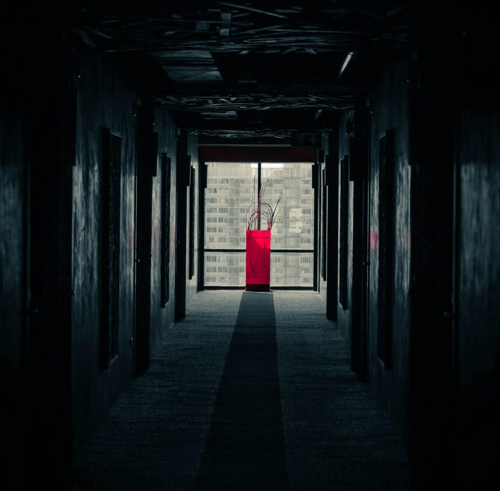 Shadowy hallway with a distant window view, evoking mystery in a Bangkok building.